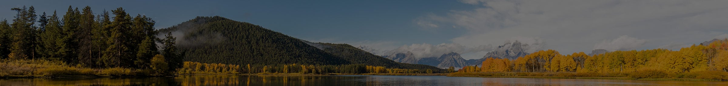 Scenic lake view of Cody/Yellowstone Country with rolling hills and mountains in the distance