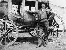 Buffalo Bill standing beside a stagecoach
