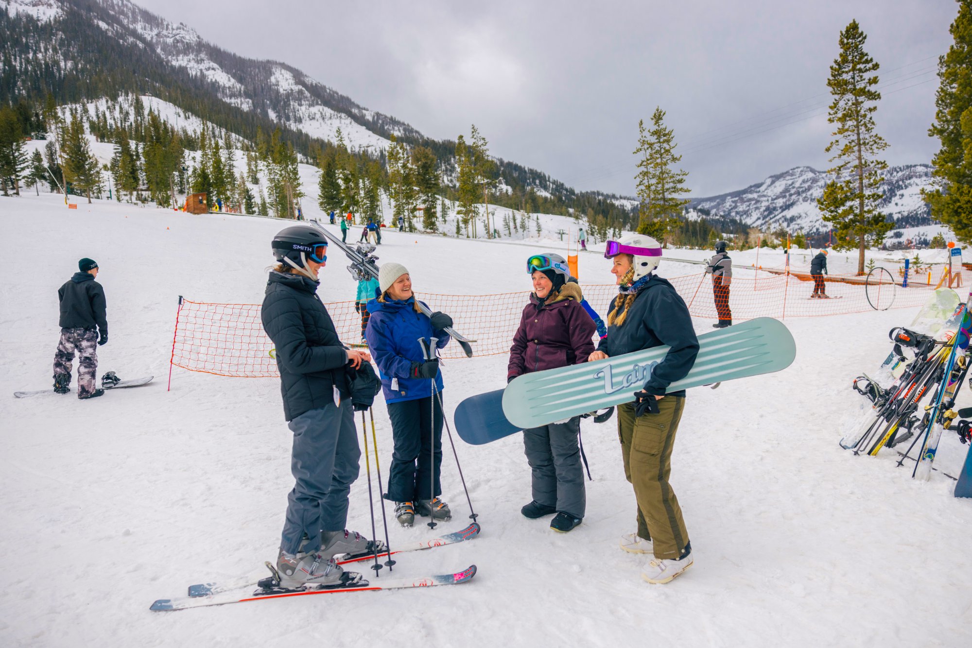 Friends with skies and snowboards chat at the base of Sleeping Giant in Cody Yellowstone