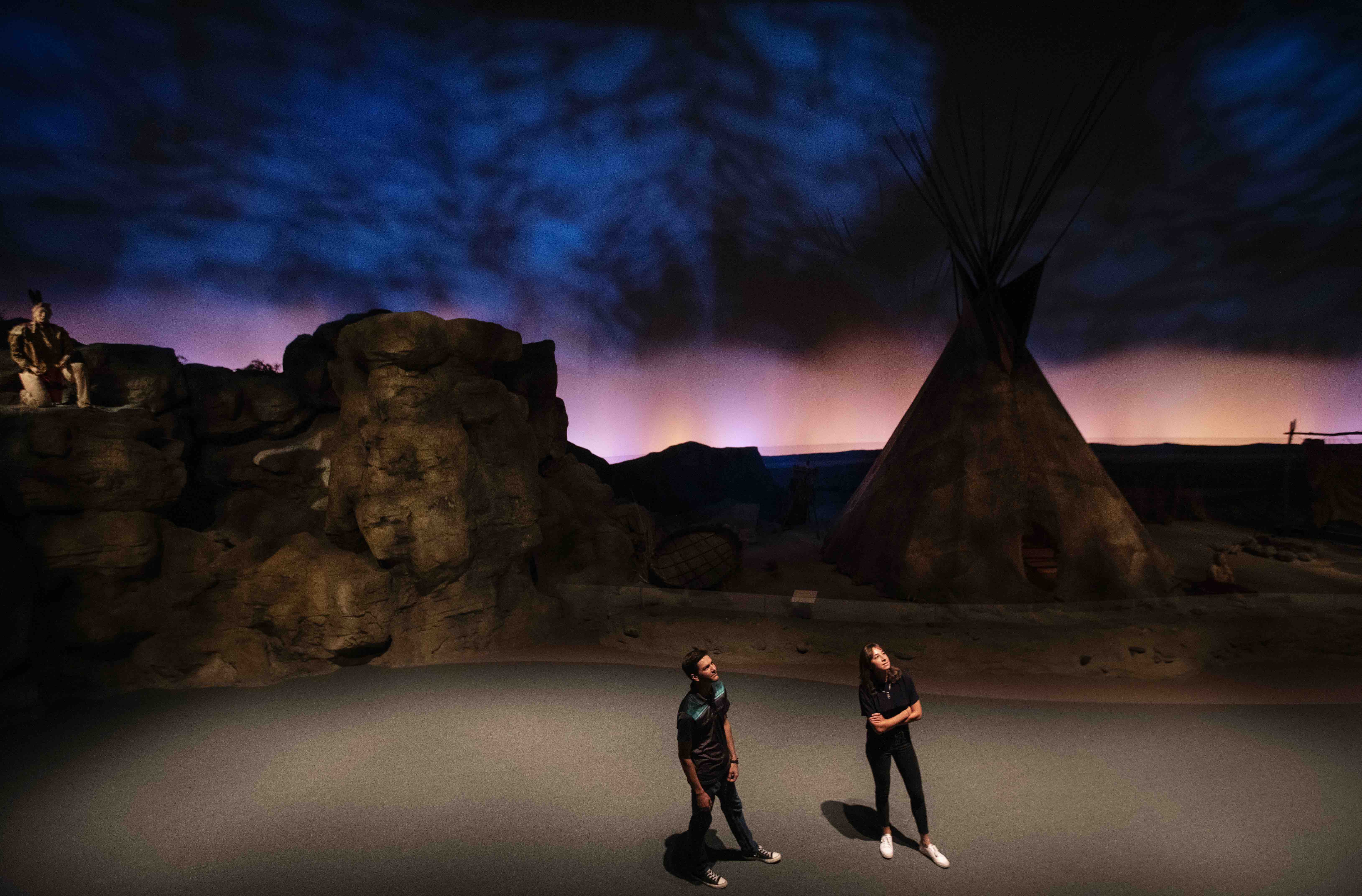 Two people watching the Nez Perce Tipi at the Plains Indian Museum