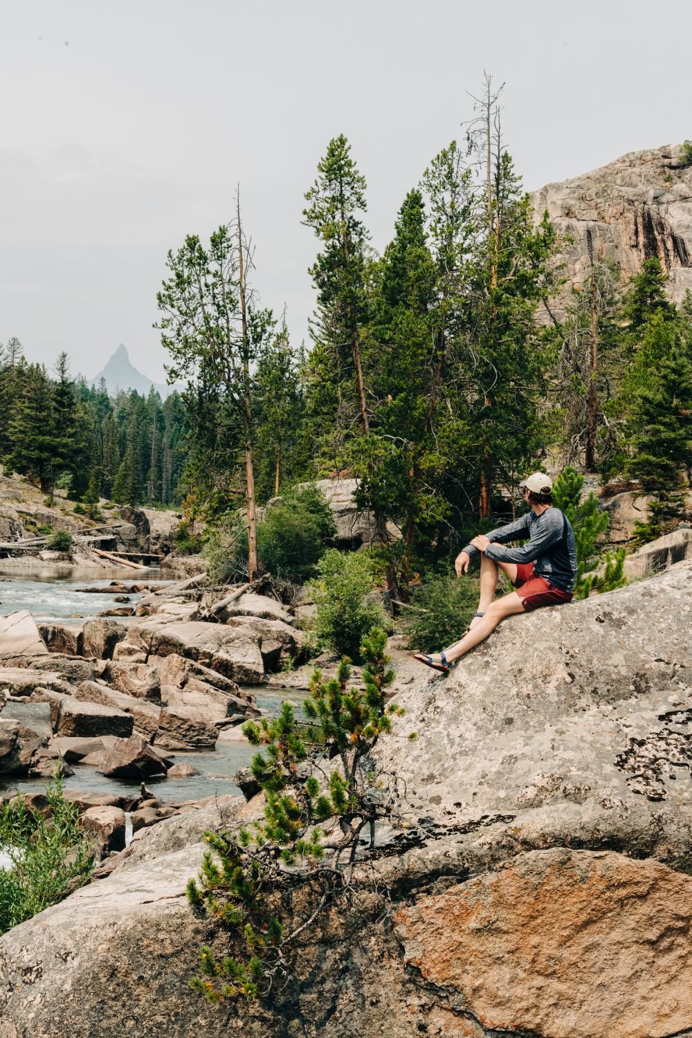 A man sits on a rock during a hike near Beartooth 