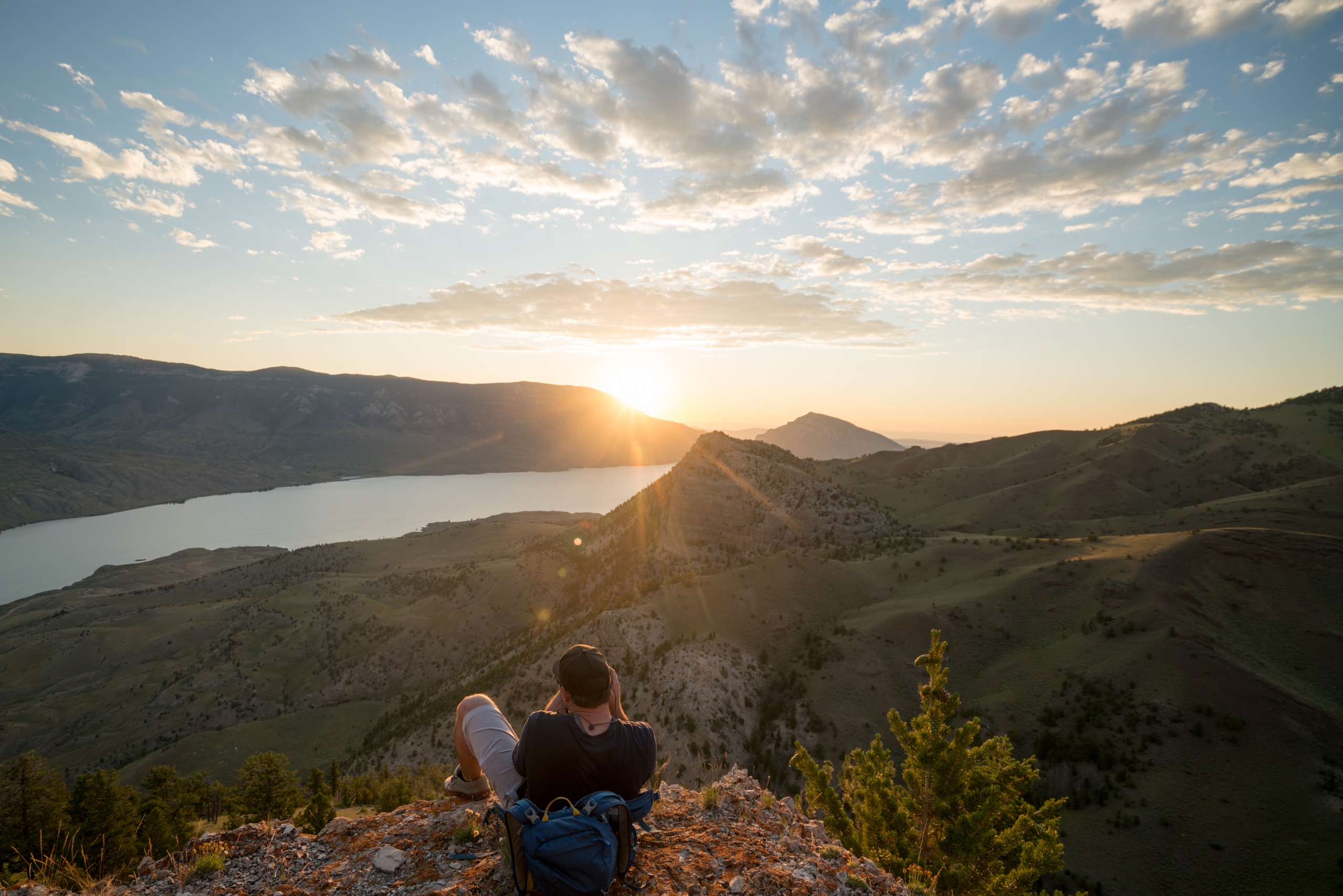 A man watches the sun set over the Buffalo Bill Reservoir