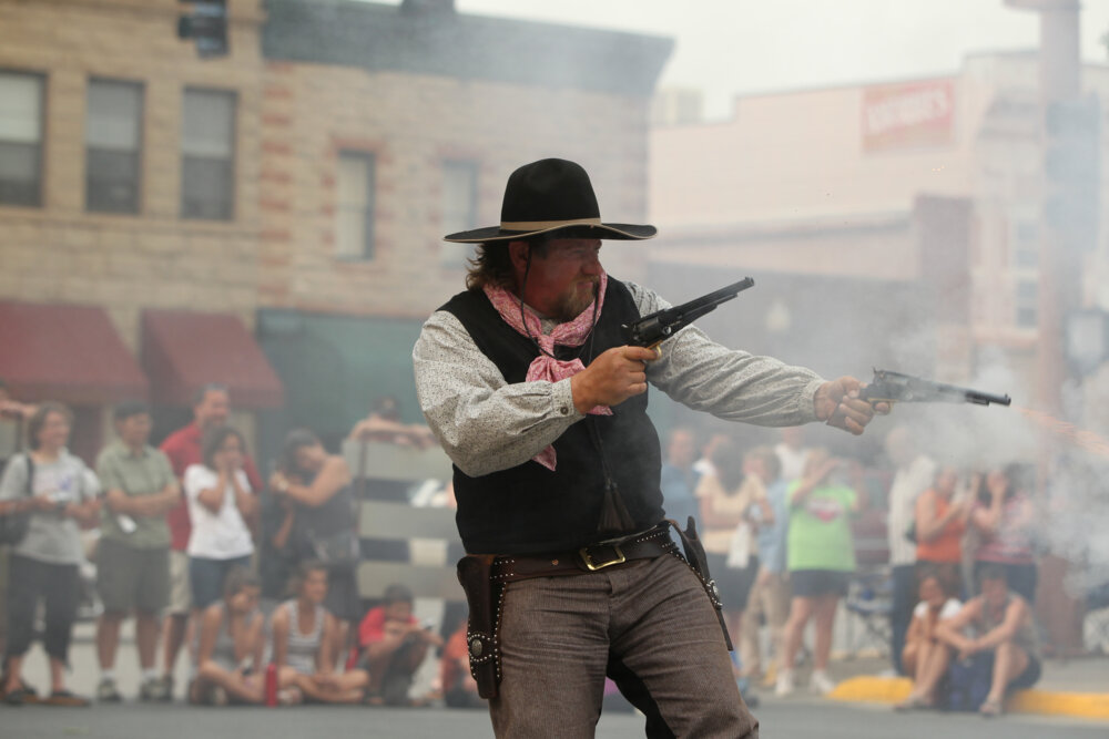 An actor in the Wild Bunch Gunslingers performs for a crowd