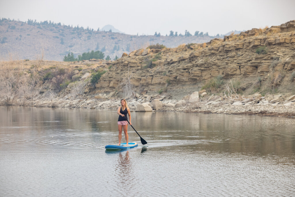 A woman paddle boards near Cody Yellowstone 
