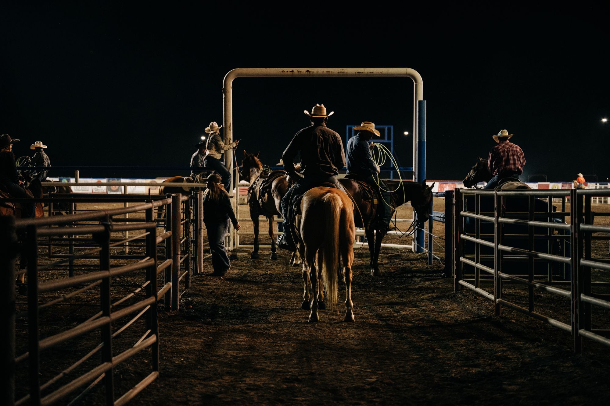 A dramatic shot of cowboys entering the ring at the Cody Nite Rodeo in Cody Yellowstone