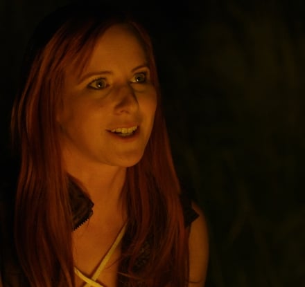 Ashley Hlebinsky sitting in front of a fire