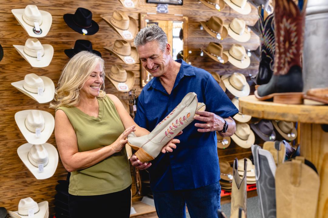 A man and woman shop for boots