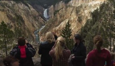 Tourists taking photos of an river running through the mountains