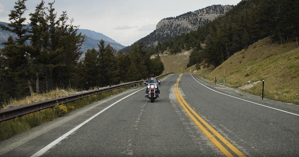 A person on a highway driving a motorcycle.