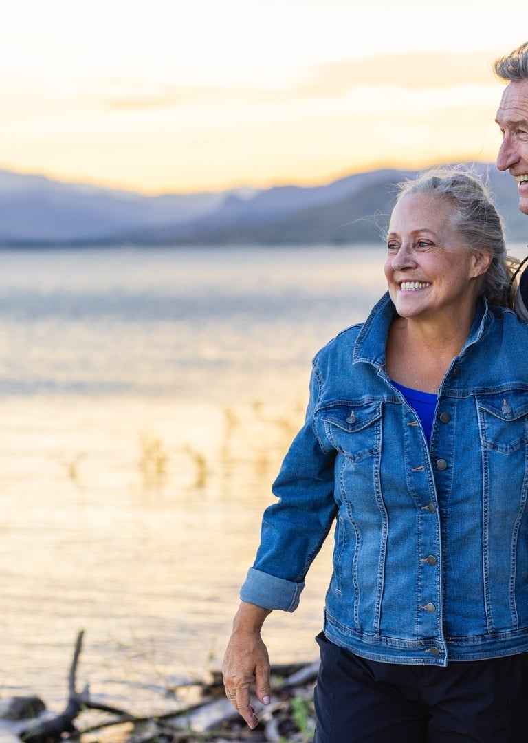 A mature couple walks along Buffalo Bill Reservoir at dusk