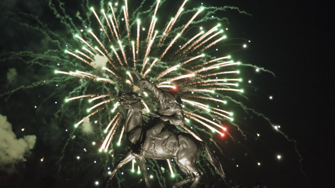 Fireworks in the background with statue of Buffalo Bill Cody in for foreground