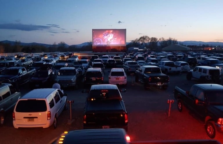 A bunch of cars parked at a drive-in theatre