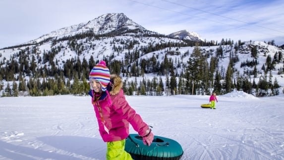 A little girl walks with a snow tube at Sleeping Giant in Cody Yellowstone